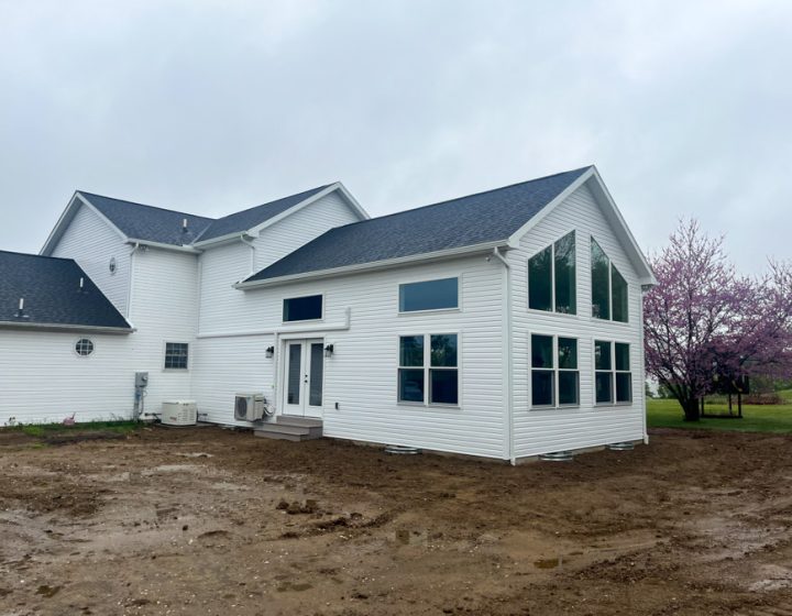 Newly added home extension featuring large windows and white siding, enhancing the modern aesthetic of the property.