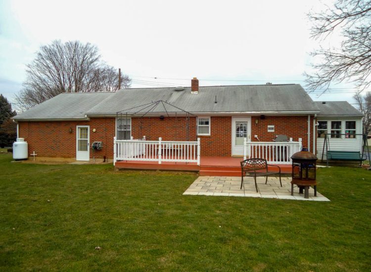 A well-maintained backyard showcasing a new patio and deck area, perfect for family gatherings and outdoor dining.